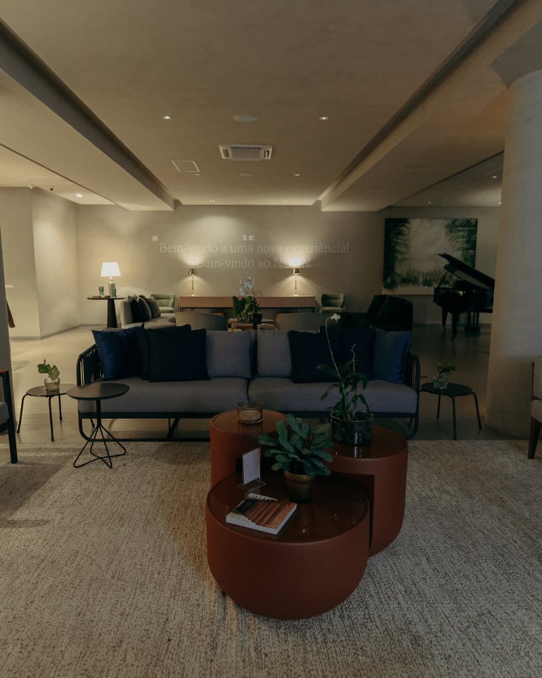 Lounge interno com sofá e piano ao fundo